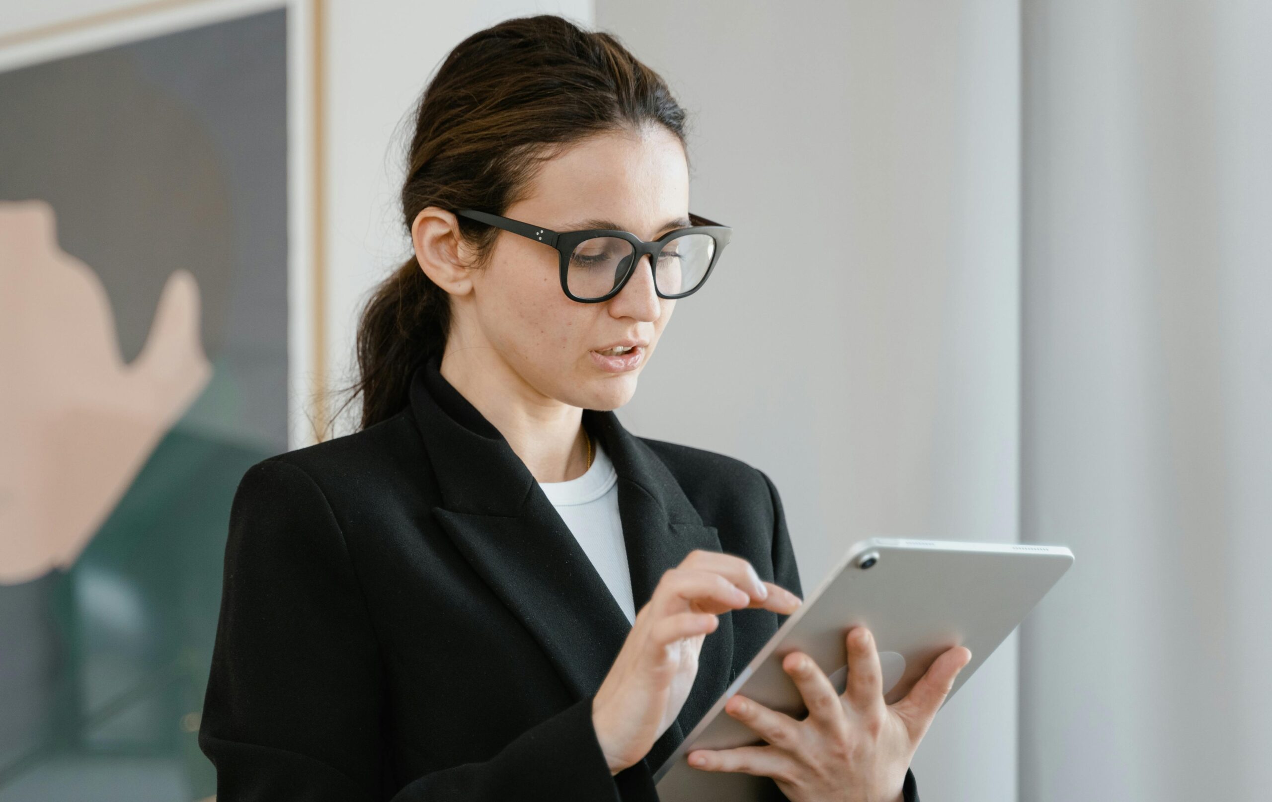Business woman with a thoughtful expression on her face looking at a tablet screen